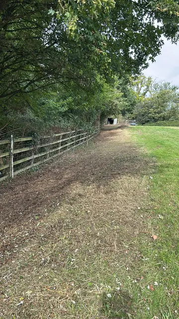 Overgrown boundary path cleared back to clean, usable ground